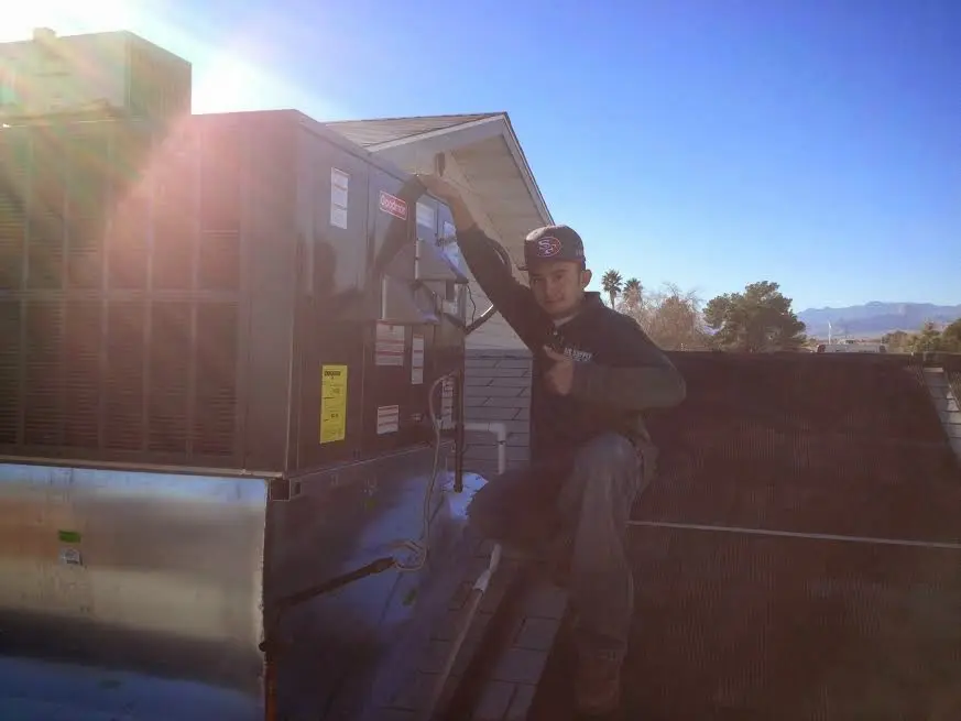 HVAC technician performing Boiler Repair on a rooftop unit in Sterling